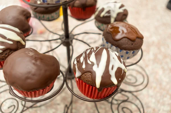 Große zarte Präsentation von leckeren Schokolade Cupcakes sitzen nebeneinander mit verschiedenen Belägen verschiedene Pralinen — Stockfoto