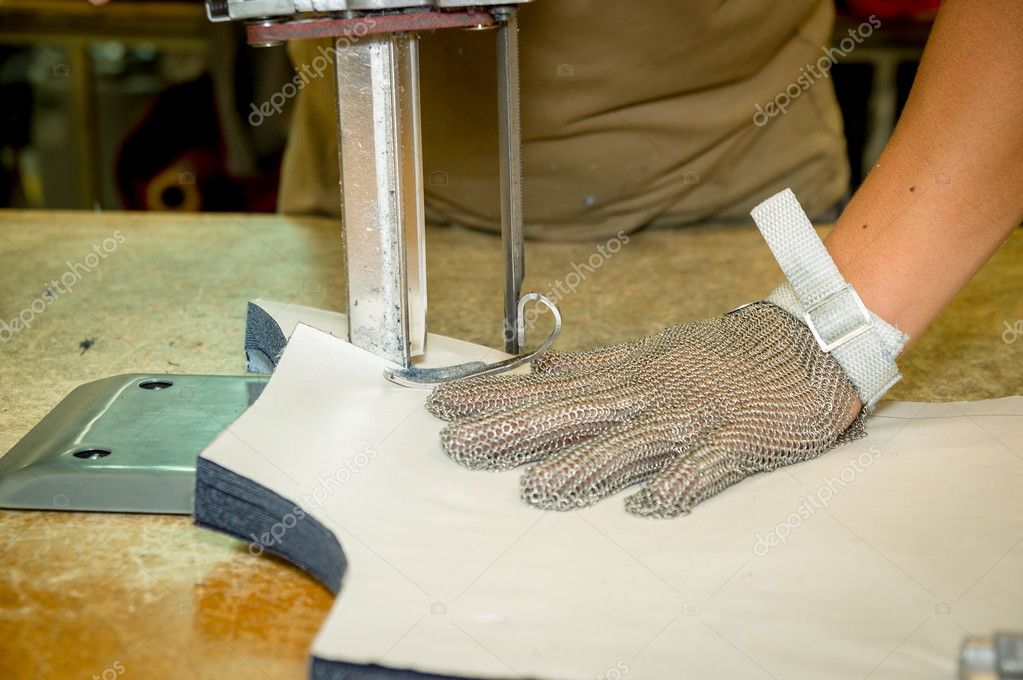 Hands wearing protection gloves using industrial machine for cutting  carpets, textiles and other heavy duty fabrics — Stock Photo © pxhidalgo  #86786088