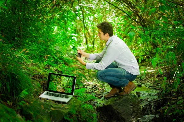 Όμορφος νεαρός με τη μεγάλη συνδετικότητα Διαδικτύου στο δάσος ζούγκλα — Φωτογραφία Αρχείου