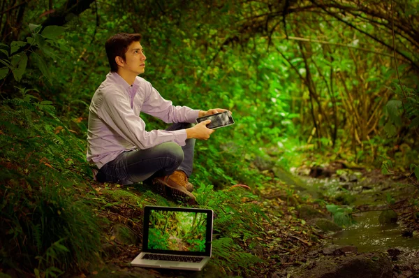 Junger gutaussehender Mann mit toller Internetverbindung im Dschungel — Stockfoto