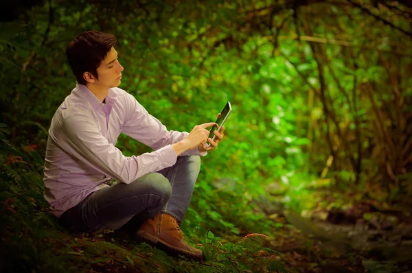 Junger gutaussehender Mann im Dschungel mit Tablet im Freien und toller Internetverbindung — Stockfoto