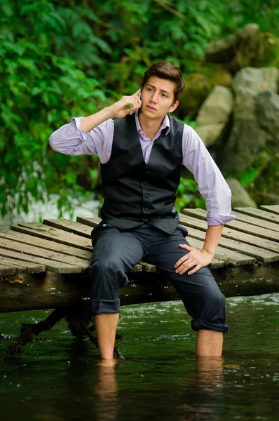 Eleganter junger Mann benutzt Handy in einem See — Stockfoto