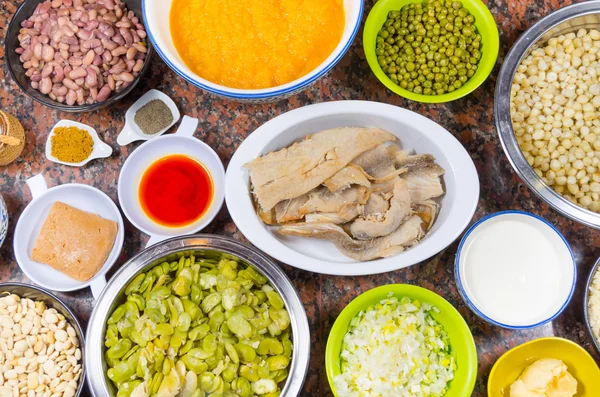Bowls of different ingredients spread out on granite surface including green peas, onions, abbas, corn, fish, lupini and red beans — Stock Image Bowls of different ingredients spread out on granite surface including green peas, onions, abbas, corn, fish, lupini and red beans Royalty Free Stock Photos