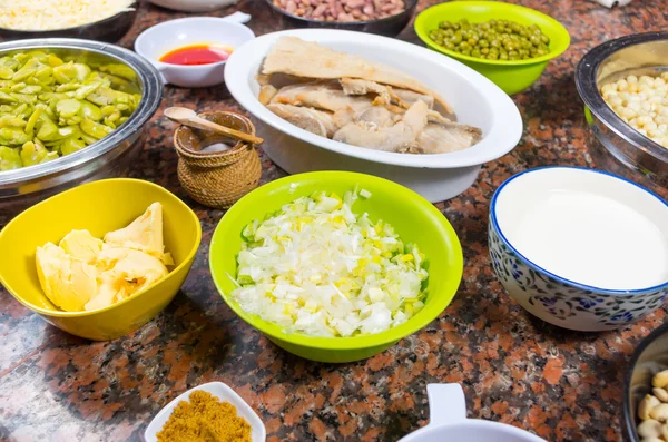 Bowls of different ingredients spread out on granite surface including green peas, onions, abbas, corn, fish, lupini and red beans — Stock Image Bowls of different ingredients spread out on granite surface including green peas, onions, abbas, corn, fish, lupini and red beans Stock Photo