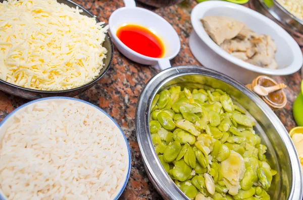 Bowls of different ingredients spread out on granite surface including green peas, onions, abbas, corn, fish, lupini and red beans — Stock Image Bowls of different ingredients spread out on granite surface including green peas, onions, abbas, corn, fish, lupini and red beans Royalty Free Stock Photos
