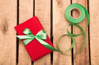 Nicely wrapped presents in red and green wrapping on wooden surface