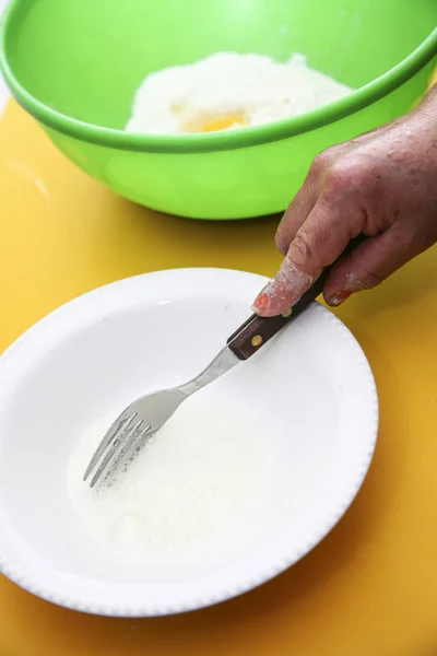Hand with fork whiiping eggwhites in white small bowl, preparing fanesca concept — Stock Photo, Image