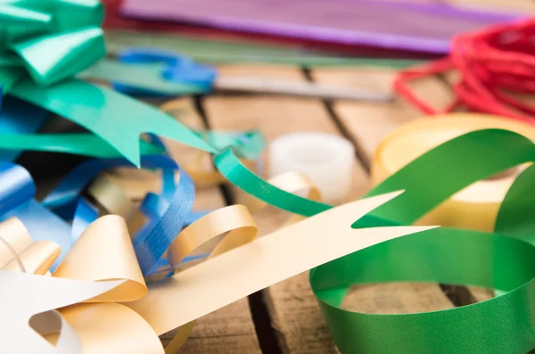Presentpapper koncept med olika pappersfärger, sax, tejp och andra decoratives liggande på träytan — Stockfoto