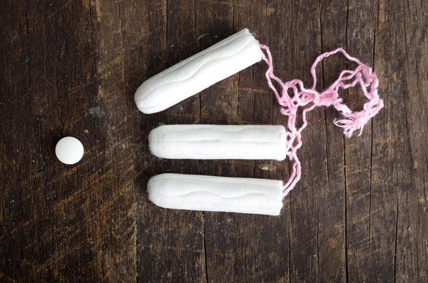 Clean white tampons lying on wooden surface — Zdjęcie stockowe