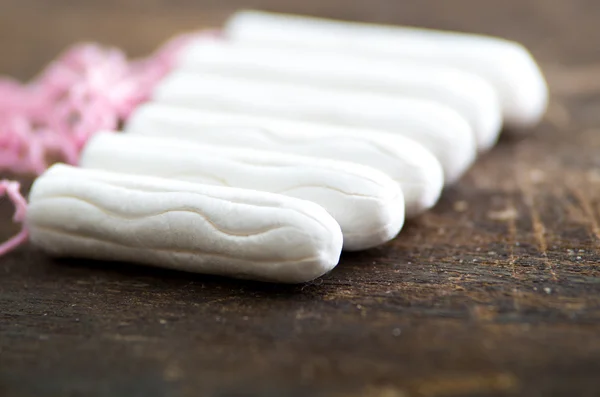 Saubere weiße Tampons liegen auf hölzerner Oberfläche — Stockfoto