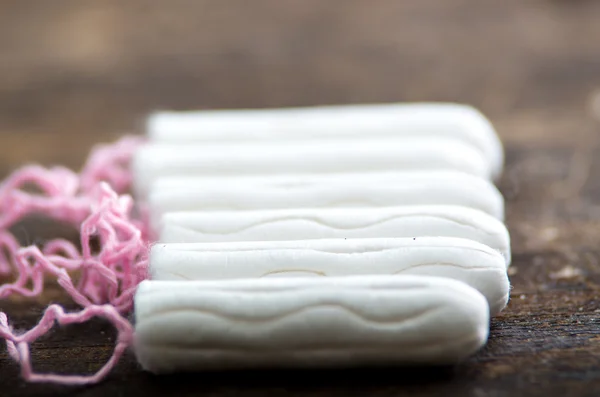 Clean white tampons lying on wooden surface — 图库照片