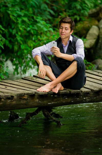 Young elegant man using cell phone in lake forest — Stock Photo, Image
