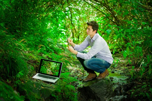 Joven hombre guapo con gran conectividad a internet en la selva —  Fotos de Stock