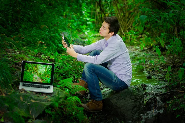 Joven hombre guapo con gran conectividad a internet en la selva —  Fotos de Stock