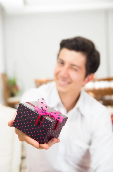 クリスマス プレゼント ボックスを保持しているハンサムなうれしそうな若い男 — ストック写真