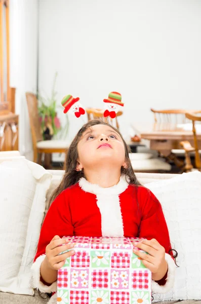 Schattig klein meisje in Kerstmis jurk bedrijf aanwezig — Stockfoto