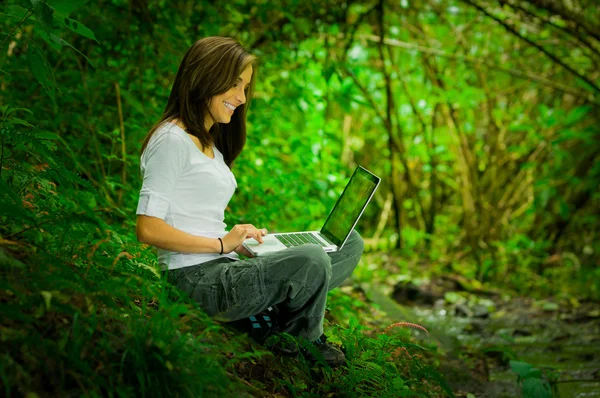 Menina bonita usando laptop ao ar livre no selvagem desfrutando de excelente conectividade — Fotografia de Stock