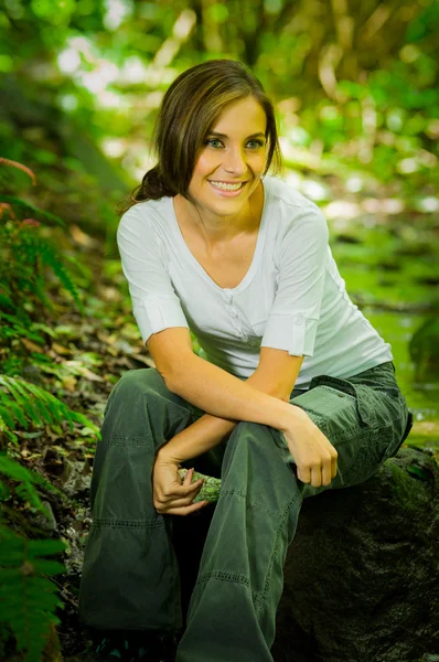 Mooie jonge vrouw zitten in de jungle — Stockfoto