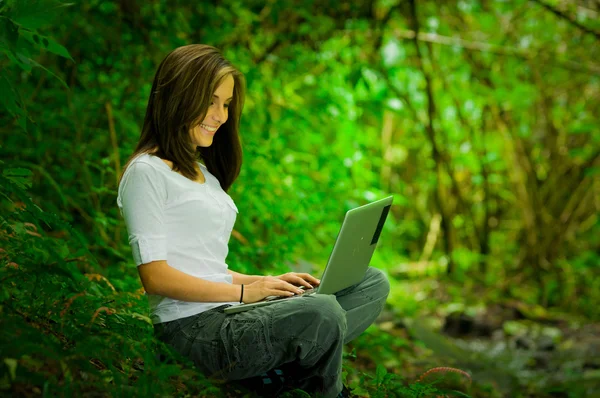 Menina bonita usando laptop ao ar livre no selvagem desfrutando de excelente conectividade — Fotografia de Stock