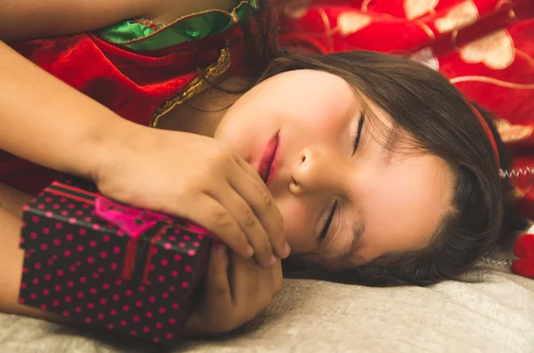 Little girl sleeping next to Christmas present — Stock Photo, Image