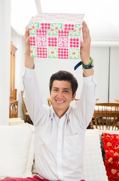 Bonito jovem alegre segurando caixa de presente de Natal — Fotografia de Stock