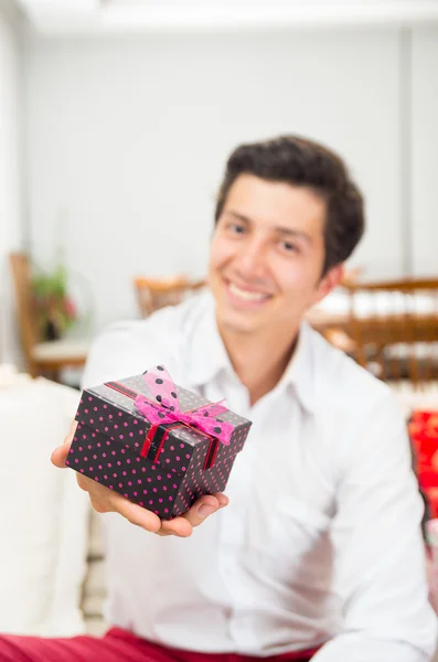 Beau jeune homme joyeux tenant boîte cadeau de Noël — Photo