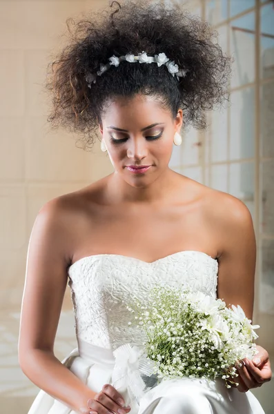 Curly brunette bride looking at flower bouquet — Stock Photo, Image