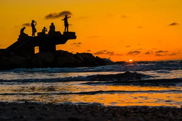 Sillhouette των ανθρώπων στην παραλία κατά τη διάρκεια του ηλιοβασιλέματος — Φωτογραφία Αρχείου