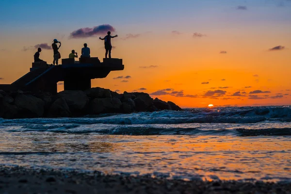 Sillhouette των ανθρώπων στην παραλία κατά τη διάρκεια του ηλιοβασιλέματος — Φωτογραφία Αρχείου