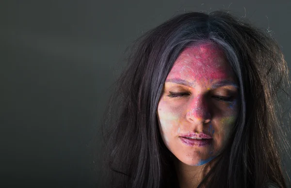 Beautiful young latin girl with colored powder on her face — Stock Photo, Image