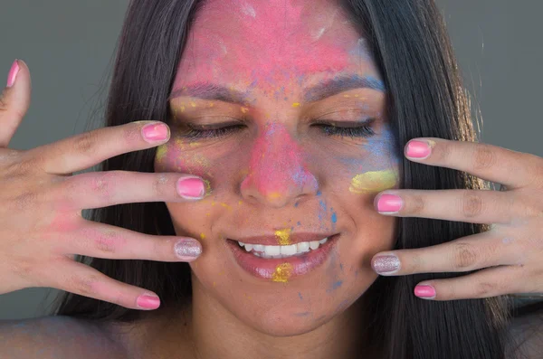 Piękna brunetka dziewczyna malowanie twarzy z kolorowy proszek — Zdjęcie stockowe