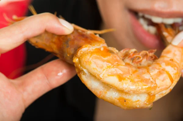 年轻女子吃大虾的镜头 — 图库照片