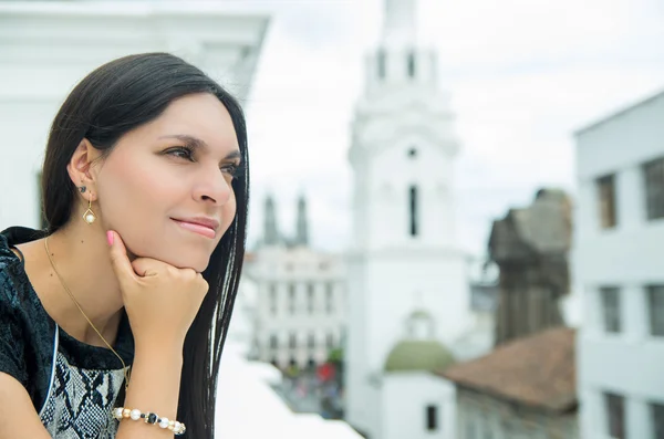 Belle brune chic portant une robe blanche noire en milieu urbain penchée sur la surface et bénéficiant d'une vue tout en souriant — Photo