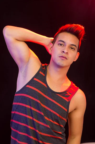 Hispanic male wearing red black striped singlet posing with serious facial expression — Stock Photo, Image