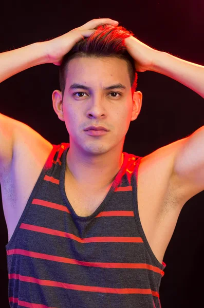 Hispanic male wearing red black striped singlet posing with serious facial expression — Stock Photo, Image