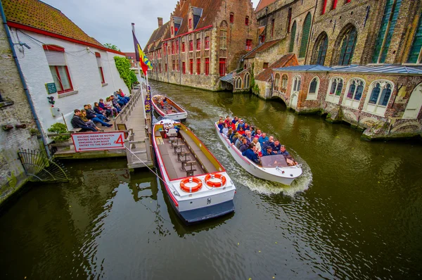 Brujas, Bélgica - 11 de agosto de 2015: Barco turístico que pasa por el canal rodeado de una espectacular arquitectura antigua a ambos lados — Foto de Stock