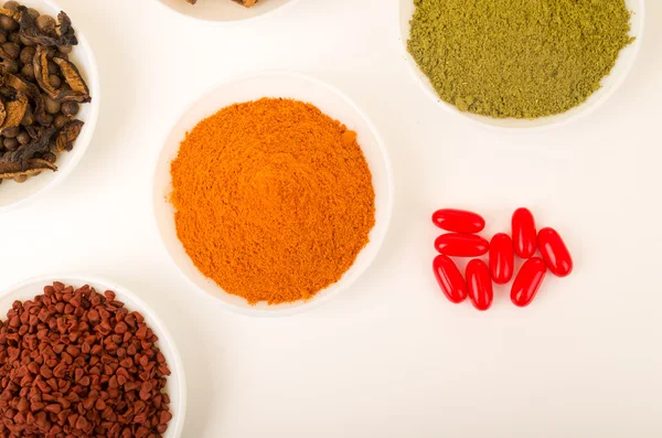 Beautiful colorful display of different spices green orange brown in white bowls, shot from above angle, bright background — Stockfoto
