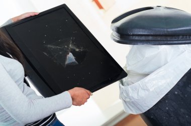 Broken computer screen going into large black trash dumpster