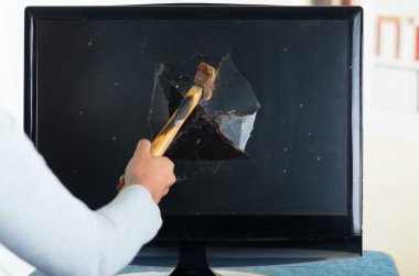 Female holding hammer smashing it into computer screen