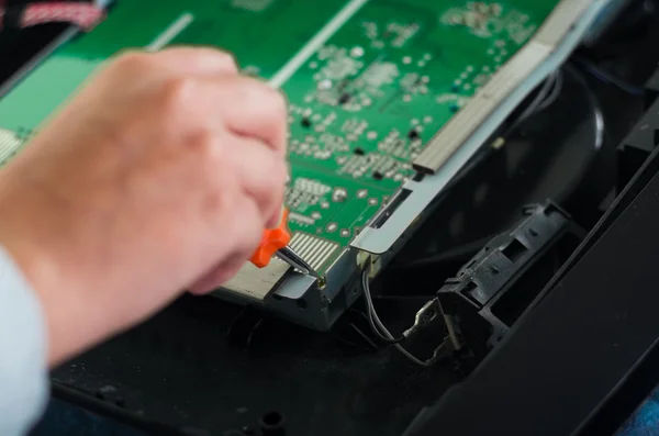 Hände arbeiten mit elektronischer Leiterplatte vom kaputten Computerbildschirm mit kleinem Schraubenzieher — Stockfoto