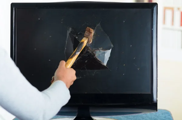 Female holding hammer smashing it into computer screen — Stockfoto