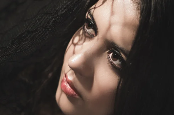 Headshot brunette model experimenting with shadows on obscure background, artistic dark beauty photo — Stockfoto