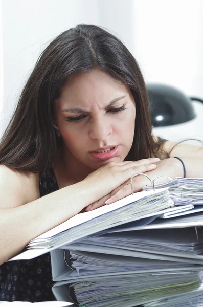 Hispanische brünette Bürofrau sitzt am Schreibtisch mit geöffnetem Papieraktenarchiv und sieht müde aus — Stockfoto