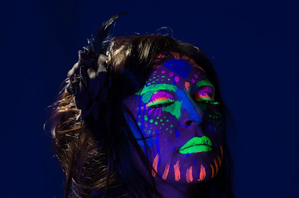 Frau mit Kopfschuss, die einen fantastischen Schein in dunkler Gesichtsfarbe trägt, blau mit anderen Neonfarben und obskuren abstrakten Hintergrund, vor der Kamera — Stockfoto