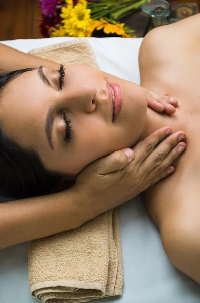 Modelo morena hispana recibiendo masaje spa tratamiento, brazos alrededor de las mujeres cuello con los ojos cerrados — Foto de Stock