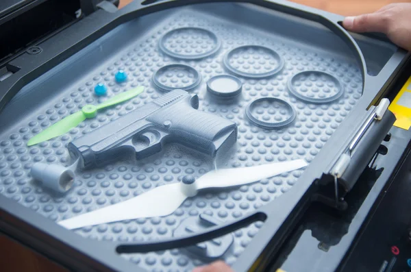 Black rubber rings, toy gun and small propellers lying on plastic bubble surface, print screen process — Stock Photo, Image