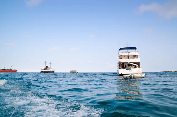 Several smaller ships outside Galapagos islands sailing on beautiful blue pacific ocean — Stock Photo, Image