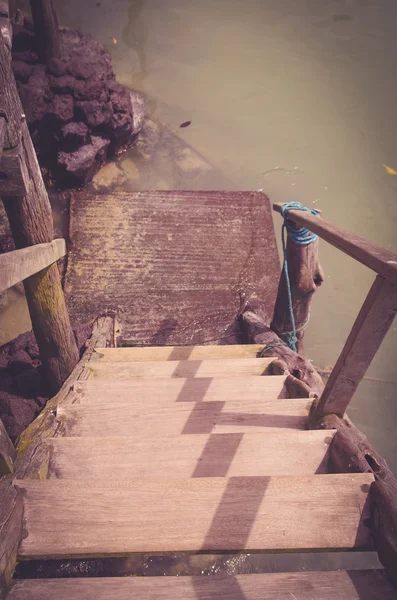 Küçük rıhtıma çamur ile eski ahşap merdiven okyanus su renkli — Stok fotoğraf