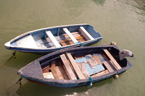 Två små enkla trä fiskebåtar binds upp i grön lera färgat vatten — Stockfoto