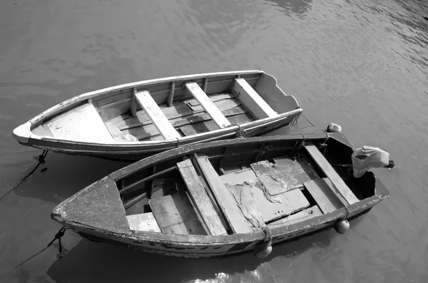 Zwei kleine einfache hölzerne Fischerboote, die im grünen schlammfarbenen Wasser festgebunden sind — Stockfoto